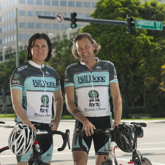 Bill Bone and Mark Hassall Wearing Cycling Kits Standing Outside the Bill Bone Bike Law Office in West Palm Beach